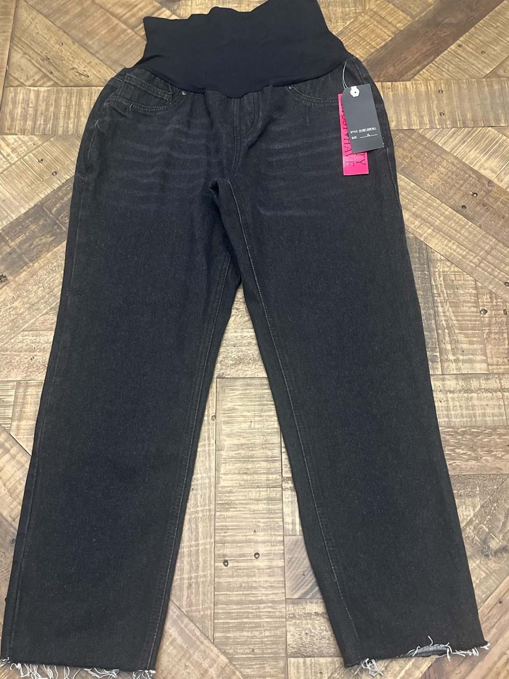 Blue Savvy black maternity jeans feature a raw hem and a stretchy waistband.